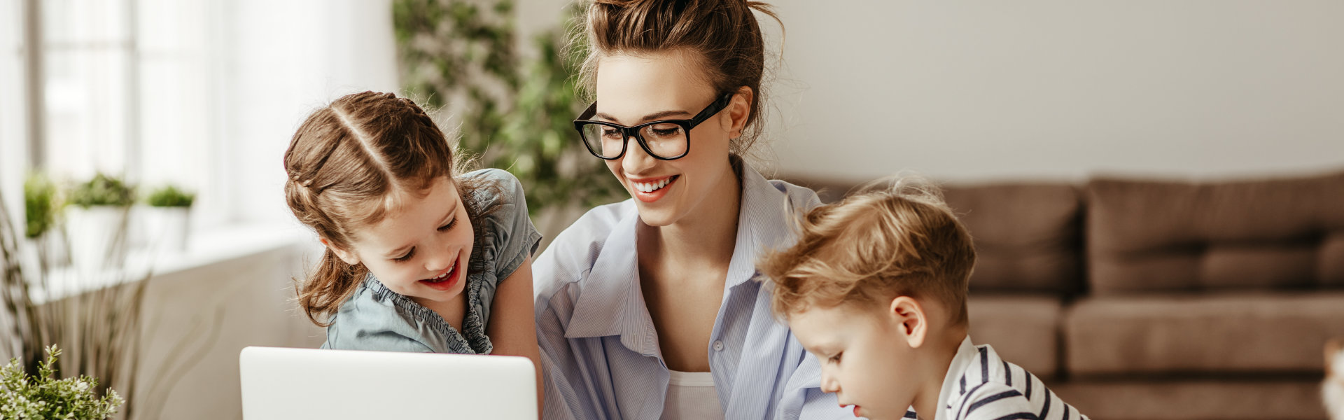 woman using laptop with two children